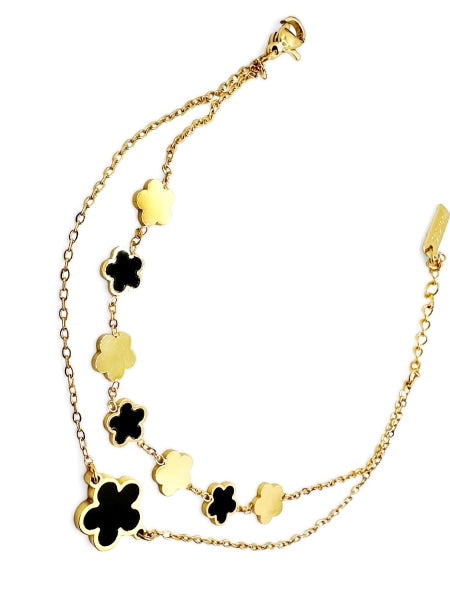 Golden colored stainless steel bracelet with 7 small clovers colored golden and black and one big black clover.